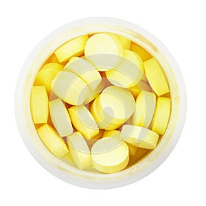 Top view of yellow pills in round plastic bottle