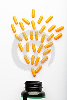 Top view of yellow Pills spilled from a bottle