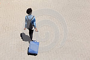 Top view young afro american woman walking on the street with luggage