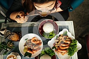 top view young asia woman eating in restaurant with seafood fried shrimp and rice on wooden table background