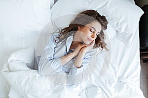 Top view of young beautiful woman in pajamas sleeping peacefully photo