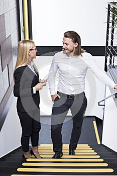 Top view at young business couple standing on stairs in office