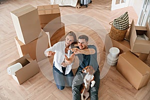 Top view. Young couple with dog are moving to new home