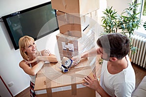 Top view of young couple packing things in boxes.  packing, moving, new beginning, concept