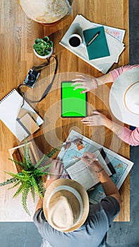 Top view of young couple with tablet planning vacation trip, desktop travel and green screen.