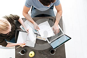 Top view of young couple work with papers and laptop at home