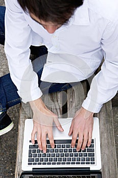 Top view of a young man typing on laptop