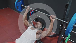 Top view of young muscular afro man exercising bench press chest on the bench with barbell