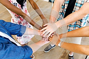 Top view of young people putting hands together