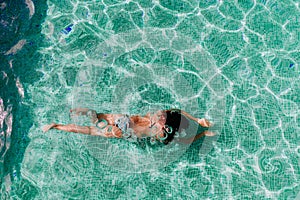 Top view of young woman diving underwater in a pool. summer and fun lifestyle