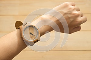 Top view. young woman equip wooden wrist watch on her arm have w