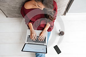 Top view of a young woman holding laptop computer