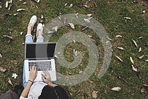 Top view of a young woman holding laptop computer on her lap