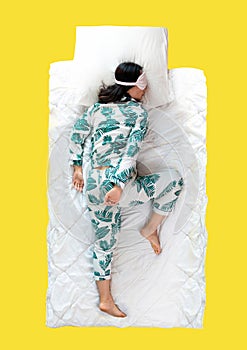 Top view on a young woman lying in bed while taking a break from work and sleeping tight at home.