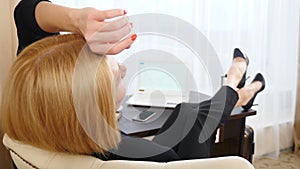 Top view on young woman relaxing sitting on cozy armchair after work satisfied with goals achieved, resting hands behind