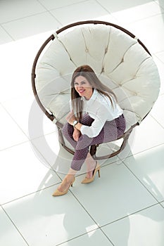 Top view.young woman sitting in soft round chair