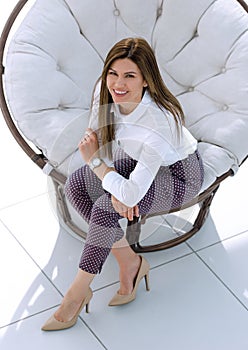 Top view.young woman sitting in soft round chair