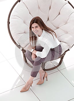 Top view.young woman sitting in soft round chair
