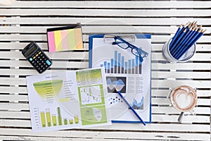 Top view of young working woman using laptop and reading report , graphs , charts, document at work