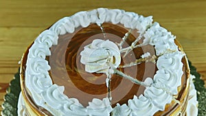 Top view zoom out from round caramel cake with white cream divided into parts