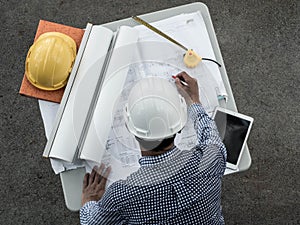 Top viwe, Engineers in helmets planning new project on table. Architect working on blueprint