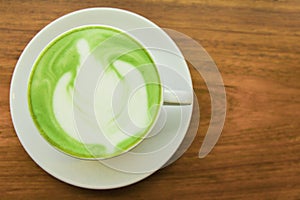 Top viwe. Milk green tea latte in cup on wood photo