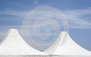 Top of white canvas tent on cloudy sky