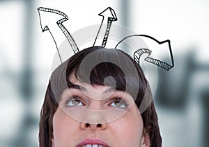 Top of woman's head and upward arrows against blurry grey office