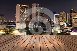 Top wood desk with urban city night view blur background,wooden table