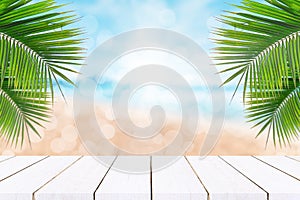 Top of wood table with seascape and palm leaves, blur bokeh light of calm sea and sky at tropical beach background.blurred blue