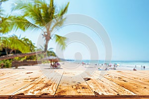 Top of wood table with seascape, palm tree, calm sea and sky at tropical beach background