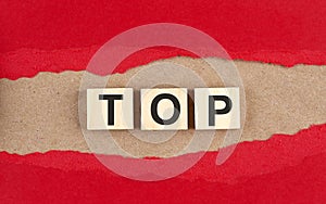 TOP word on wooden cubes on red torn paper , financial concept background