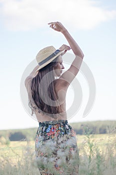 topless brunette woman in straw hat in the field