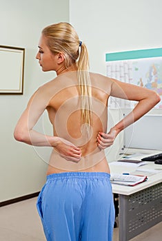 Topless female patient back pain