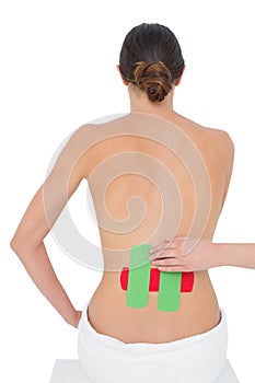 Topless fit woman with red and green strips on back