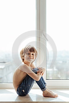 Topless kid portrait near the window