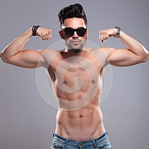 Topless man flexes his biceps