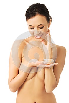 Topless woman with cream container