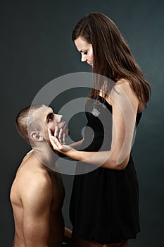 Topless young man kneels before his girlfriend