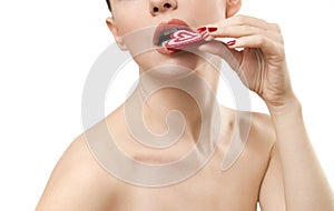 Topless young woman eating heart shaped candy