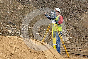 Topographical survey of the terrain by a surveyor at the construction site
