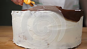 Topping chocolate dessert. Melted Chocolate being spread on Delicious Cake. Mouthwatering chocolate cake in white glaze