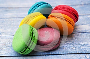 Topshot of sweet and colourful french macaroons on blue wooden background