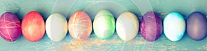 Topview, colorful dyed easter eggs on blue vintage wooden table photo
