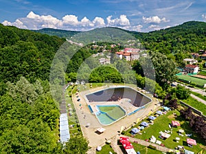 Topview from a drone over the pool surrounded by green trees