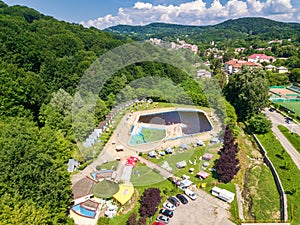 Topview from a drone over the pool surrounded by green trees
