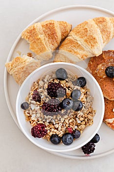 Topview image of yummy breakfast. Granola with berries, croissan