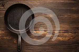 Topview of an old grill pan, empty, on rustic oak