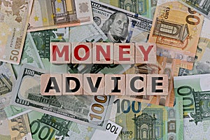 Topview photo on money advice theme. wooden cubes with the inscription `money advice`,  on the background of dollar and euro bills