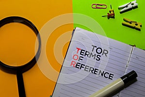 TOR. Terms Of Reference acronym on book. Office desk background